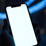 Hoaks! Surat Komdigi soal Internet Nasional Padam 25–27 September 2026 Dipastikan Palsu Ilustrasi tangan memegang ponsel dengan layar menyala di malam hari