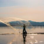 Penjala ikan menebar jala di perairan Rowo Jombor Klaten saat pagi